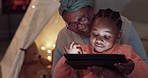 Night, tablet games and grandmother with a child for streaming a movie, cartoon or show. Happy, reading online and an African senior woman with a girl kid and tech in the dark for the web in a house