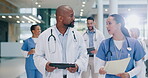 Talking, doctor and nurse with tablet in hospital lobby for advice on team surgery, report or insurance paperwork. Teamwork, woman and black man in conversation about medical information or care