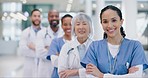 Crossed arms, success and face of group of doctors standing in the medical hospital with confidence. Happy, professional and portrait of team of healthcare workers in hallway of a medicare clinic.