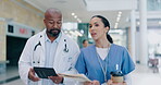 Talking, doctor and nurse with tablet in hospital lobby for collaboration, teamwork and advice on surgery, report or paperwork. Medical, team and healthcare employees in conversation on coffee break