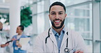 Man, arms crossed and doctor, face and health with smile, confidence and surgeon at hospital. Male physician, medical expert and cardiology specialist with healthcare, portrait and happy professional