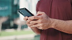 Man, phone and hands typing in city for networking, online browsing or outdoor communication. Closeup of male person chatting, texting or busy on social media with mobile smartphone app in urban town