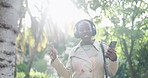 Happy black woman, phone and dancing in park to music for fun audio or outdoor streaming. African female person walking and listening to sound track, podcast or radio on headphones in the forest