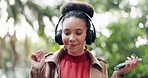 Headphones, phone or woman in park dancing, walking or streaming a song, sound or radio service to relax. Mobile, headphones or person listening to music on online subscription in nature for wellness