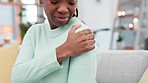 Shoulder pain, problem and black woman on sofa with arthritis, injury or fibromyalgia at home. Arm, accident and African lady massage joint for osteoporosis, osteoarthritis or muscle cramps in house