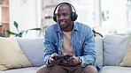 Man, headphones and video game with controller, sofa and excited for virtual user experience, streaming or esports. Young guy, online gaming and thinking with press, click and strategy for challenge