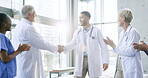 Meeting, applause or doctors shaking hands for success, good job or promotion in a hospital clinic. Group clapping, congratulations or proud healthcare worker with handshake for teamwork or thank you