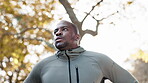 Fitness, thinking and a tired man outdoor for exercise break, rest or to breathe after a run or workout. African person, athlete or runner in nature for health, wellness and training for sports