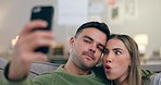 Funny face, love and a couple for a selfie on home sofa for connection, social media or memory. Young man and woman together on couch for profile picture for internet, kiss or healthy marriage