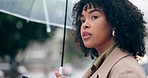 Phone, umbrella and a woman waiting for a taxi in the rain while in the city for a winter commute. Water, street and ride share with a young pedestrian using an app to call a cab for urban travel