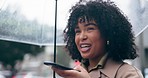 Phone call, raining and woman with an umbrella in the city walking on speaker with cellphone. Technology, voice recognition and young female person from Colombia recording a mobile message in town.