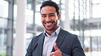 Thumbs up, wink and a business man walking in the office with a smile for a professional job opportunity. Portrait, mindset or motivation and a happy young corporate employee at work with a yes emoji