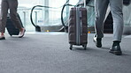 Businessman, feet and walking in airport with luggage for journey to convention, conference or employee travel for work. Moving, suitcase and shoes on escalator or floor in flight terminal or lobby