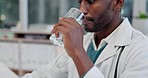 Doctor, drinking water and blank man in a hospital or healthcare clinic for medical work. Glass, african male professional and employee at a office desk with health research and computer with email