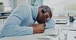 Call center, customer service and tired male consultant in the office yawning and sleeping by desk. Exhausted, overworked and bored African man telemarketing or sales agent taking nap in workplace.