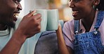 Tea, toast and conversation with a black couple on a sofa in the living room of their home together. Coffee, love or cheers with a man and woman talking in their house while drinking a beverage