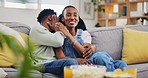 Movie, horror and couple hug watching tv on a sofa, happy and playful in their home together. Love, television and man embrace scared black woman in living room bonding while streaming series or film