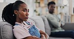 Sofa, angry and black woman in a fight with a man for divorce, stress and thinking of conflict. House, sad and an African couple on the couch with marriage stress, problem or frustrated with mistake