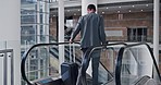 Business man, luggage and airport escalator for walking, global travel and international flight schedule in New York. Entrepreneur, steps and suitcase on stairs, back and hotel for working holiday