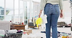 Woman, housekeeper and cleaning basket in dirty living room, germ or bacteria removal at home. Rear view of female person, maid or domestic cleaner and tools on floor in clean hygiene or disinfection