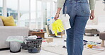 Back, cleaning and a woman in a messy living room for housekeeping or chores in the home closeup. Product, bacteria and gloves in a basket for hygiene with a female cleaner ready for housework