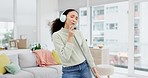 Cleaning, music and woman singing with broom in a living room, headphones and fun on day off in her house. Home, karaoke and female sing to radio, podcast or audio earphones track during spring clean