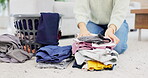 Hands, fold laundry and pile of clean clothes in house and woman on living room floor or housekeeper in spring cleaning. Washing, basket and order stack of clothing or person working in home service