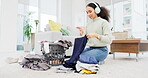 Clean, house and woman folding laundry on living room floor or housekeeper, spring cleaning and listening with headphones. Washing, clothing and stack of clothes in home or person working with music