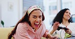 Excited women on sofa, winning at video games, fun and relax in living room of home with internet streaming. Online gaming, esports and happy young gamer girl on couch with celebration of achievement