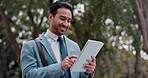 Networking, tablet and businessman in an outdoor park browsing on social media while walking. Happy, nature and young male lawyer scrolling on a mobile app with digital technology while commuting.