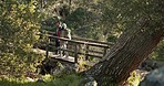 Hiking, forest bridge and couple outdoor on a jungle path for exercise, workout and adventure. Walking, trekking and young people in nature in woods for travel fitness journey together and talking