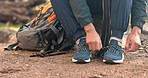 Hiking, nature and hands tie shoes outdoors for workout, exercise and walking in forest or woods. Travel, fitness and closeup of person with sneakers on ground for adventure, freedom and trekking