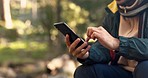 Hands, phone and man hiking in a forest texting, search and using map, navigation and travel guide in nature. Smartphone, app and male hiker online for location, sos or checking message in a jungle