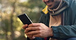 Man, hands and smartphone with typing, hiking in nature park and communication with social media. Hiker using phone, mobile app and chat, trekking or camping with technology, connectivity and contact