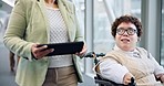 Tablet, travel and a woman with a disability in a hotel talking to a carer in a wheelchair for mobility. Hospitality, airport and an employee in a lobby or terminal for a flight with her assistant