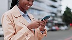 Business, black woman and smartphone in city for typing on social network, website info and internet contact. Happy worker reading news app, media or mobile communication on cellphone in urban street