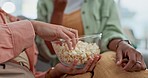 Hands, relax and people with popcorn on sofa for a movie, film or streaming a show. Closeup, sitting and friends on a home couch with a healthy snack or food in a bowl together for bonding and love