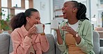 Funny, women and friends on a couch, coffee and bond while sharing gossip, humor and conversation. Happy girls, home and people on a sofa, tea and cappuccino in a lounge, laughing and communication