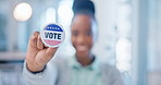 Hand, vote and badge with a black woman in government for support or motivation of a political campaign. Portrait, smile and democracy with a happy voter holding her pin of choice in a party election