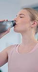 Face, gym and woman drinking water for sports break, energy and workout performance. Thirsty athlete, bottle and nutrition for hydration, diet and healthy recovery for training, exercise and fitness 