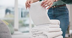 Laundry, hands and woman packing towel and cleaning in a home living room doing housework for hygiene. Sorting, service and young tidy person or cleaner working on household task in a lounge