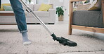 Feet, carpet and vacuum cleaner for spring cleaning in a home with a person in the living room closeup. Floor, appliance and equipment with an adult in an apartment for housework or housekeeping