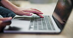 Person, laptop and hands typing with credit card in online shopping, payment or banking on desk at home. Closeup of shopper with debit or filling bank details on technology in ecommerce on table