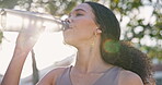 Fitness, health and drinking water with woman in park for running, sports and marathon training. Wellness, resting and exercise with person and bottle in nature for workout, cardio and hydration