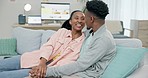 Couple, black people and laughing for communication in home with love, hug and care in living room. Man, woman and holding hands on sofa for funny joke, freedom or relax for conversation with partner