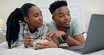 Popcorn, bedroom and couple on laptop for movie, online streaming and watching film at home. Relax, love and happy African man and woman in bed with snack series subscription on computer for bonding