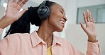Headphones, dancing and young woman with music, radio or playlist in the living room at home. Happy, entertainment and African female person listening to song or album in the lounge at her apartment.