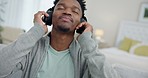Black man, headphones and dance to music,  audio streaming with stress relief and relax at home. Listening to radio, technology and subscription, energy and entertainment, lounge on couch with app