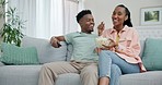 Black man, woman and couple watching tv, popcorn and online streaming, bonding and relax on couch. Happy, romance and casual date at home, movie or television show with corn snack and remote control