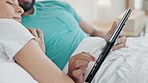 Hands, tablet and closeup of couple in bed relaxing, resting and streaming video on social media. Digital technology, love and young man and woman on the internet in bedroom at home in the morning.